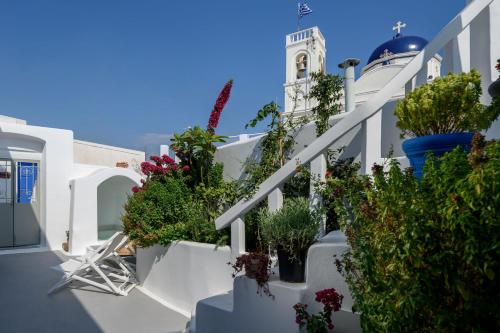 a white staircase with potted plants and a building at Betty's Home Santorini in Karterados