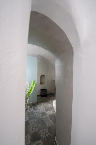 a white hallway with a room with a toilet in it at Betty's Home Santorini in Karterados