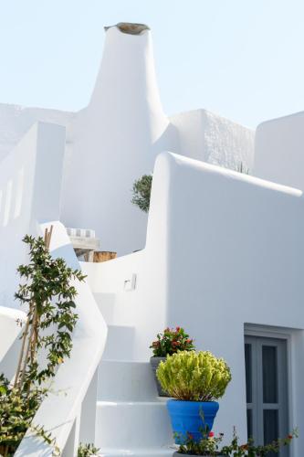 a white staircase with potted plants on it at Betty's Home Santorini in Karterados