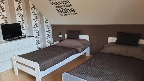 Habitación con 2 camas individuales y TV. en Nettes 2- Zimmer Apartment, en Sehnde