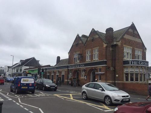 uma rua com carros estacionados em frente a um edifício em The George Inn em Braunton