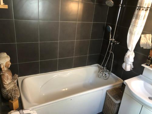 a bathroom with a white tub and a sink at Studio Duplex avec jardin terrasse La Genette Le Mail in La Rochelle