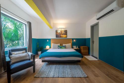 a bedroom with a bed and a chair and a window at Olive Indiranagar - By Embassy Group in Bangalore