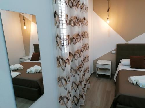 a room with two beds and a wall with shoes at B&B 36 Passi dal mare 2.0 in Trapani