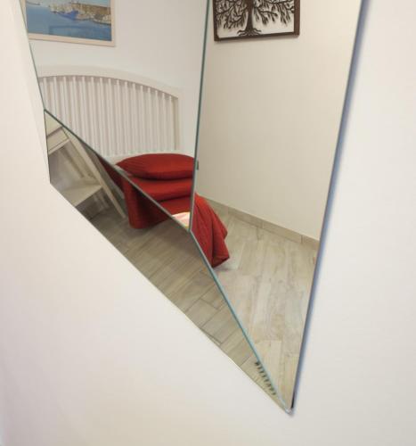 a mirror in a room with a red chair at il Riccio B&B in Ortona