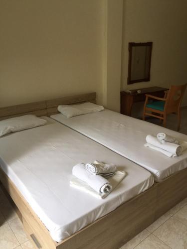 two beds with white towels on top of them at Despina Lymperi Hotel Apartments in Mirina