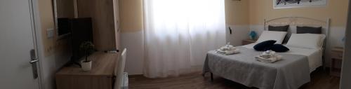 a bedroom with a bed with towels on it at Giardino dei Baroni house in Marina di Mancaversa