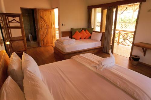 a bedroom with two beds with a cat on top of them at Akasha Beach Club in Bulukumba