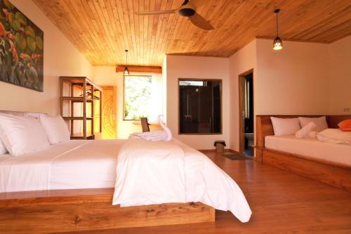 a bedroom with a large white bed and a couch at Akasha Beach Club in Bulukumba
