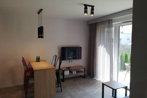 a living room with a television and a table with chairs at Apartament na Rydlówce in Krakow