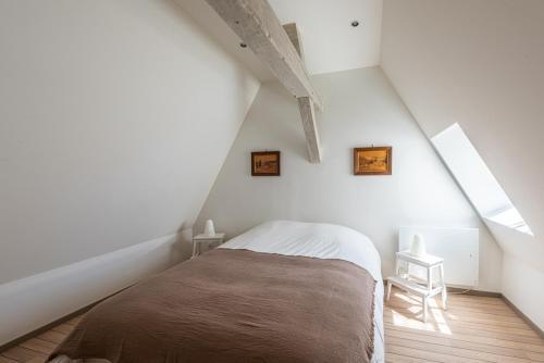 een slaapkamer met een bed op zolder bij Le Palais in Dijon