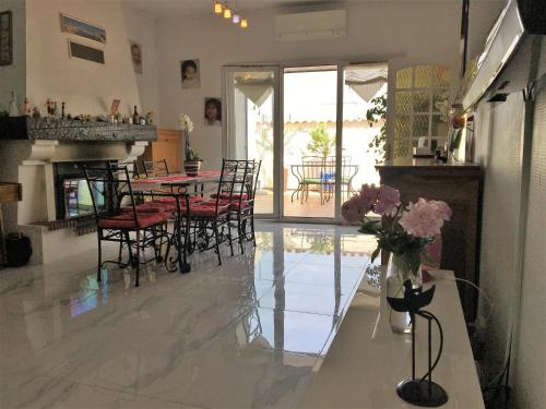 un salon avec une table et des chaises et une cheminée dans l'établissement Maison 3 chambres gde terrasse proche vieux port et sncf, à Marseille