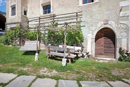 a wooden bench sitting in front of a building at Teutenhofer Zwetschge in Feldthurns