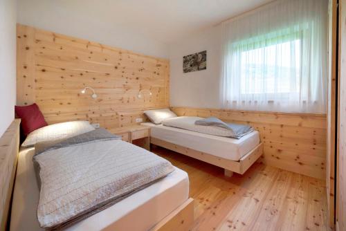 a bedroom with two beds and a window at Teutenhofer Zwetschge in Feldthurns
