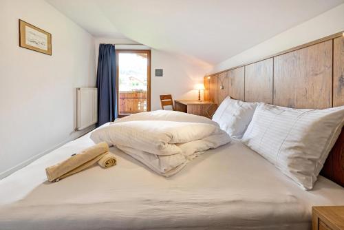 - une chambre avec un grand lit blanc et une tête de lit en bois dans l'établissement Residence Condor Apt Gitschberg, à Maranza