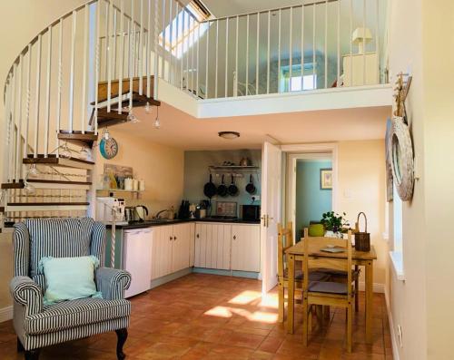 a kitchen and dining room with a table and a staircase at Tara Hill Estate in Gorey