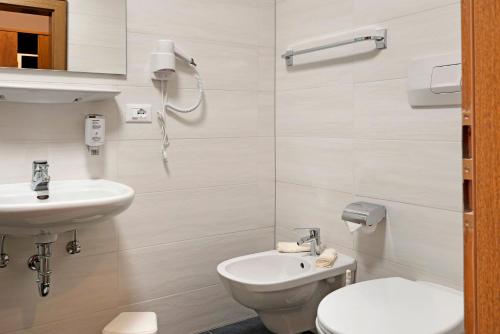 a white bathroom with a toilet and a sink at Residence Condor Apt Eidechsspitz in Maranza
