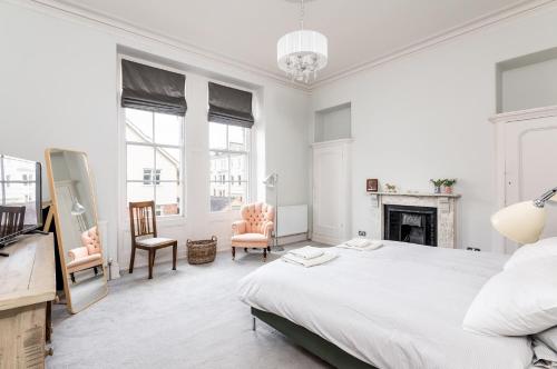 a white bedroom with a bed and a fireplace at Bright & Spacious York Apartment I Pass The Keys in York