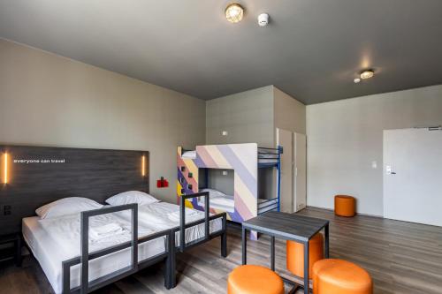 a bedroom with two bunk beds and a table and chairs at a&o Leipzig Hauptbahnhof in Leipzig