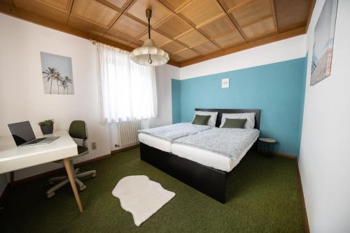 a bedroom with a bed and a desk with a laptop at Ferienhaus "La Casa" in Caldaro