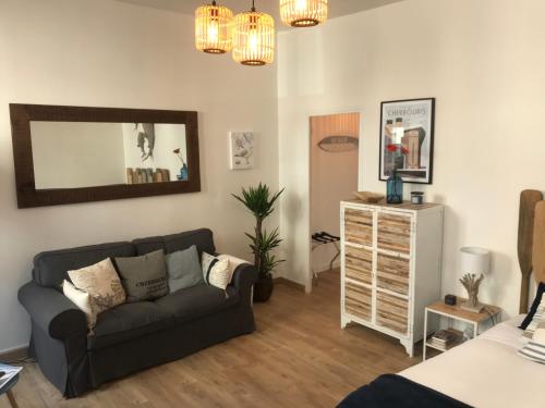 a living room with a couch and a mirror at Cherbourg Sea Sand in Cherbourg en Cotentin