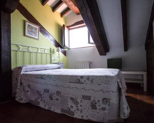 a bedroom with a bed in a room with a window at Pasaje San Jorge in Comillas