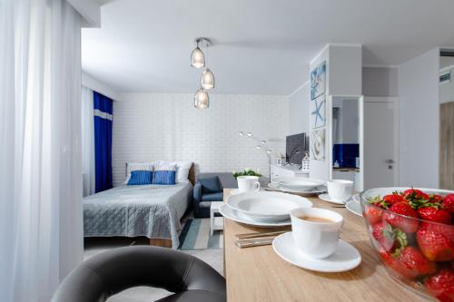una habitación con una mesa con un tazón de fresas. en Resort Apartamenty Klifowa Rewal 61, en Rewal