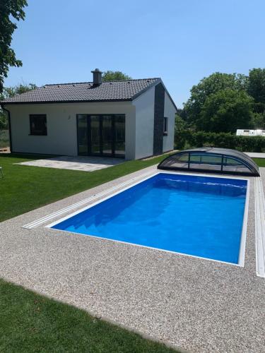 uma grande piscina azul em frente a uma casa em Vilka Petra pod Bezdězem em Weisswasser in Böhmen