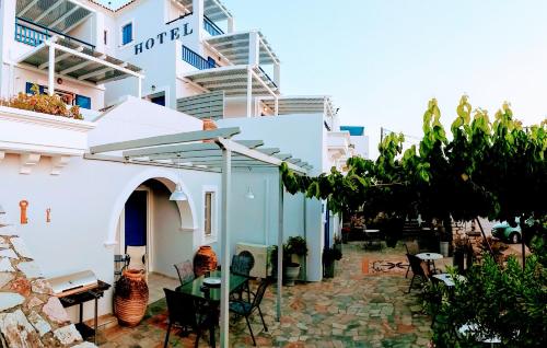 a patio with a table and chairs in front of a building at 9 Muses in Agia Pelagia Kythira