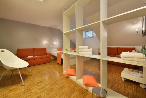 a room with a living room with orange furniture at Omnia Hotel Relax & Wellness in Janske Lazne