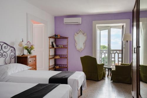 a bedroom with two beds and a purple wall at Maison Alice in Sorrento