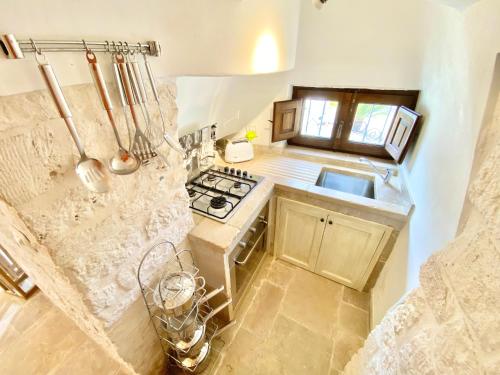 una piccola cucina con piano cottura e lavandino di Trullo SERENDIPITY ad Alberobello