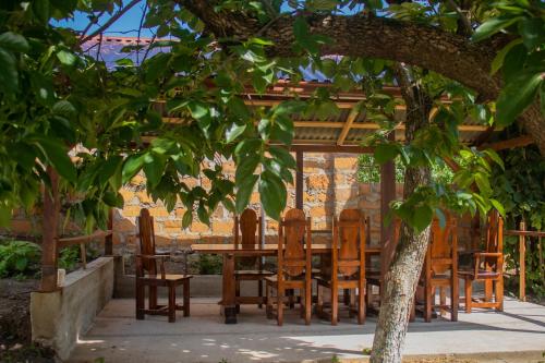 une table et des chaises en bois sous un arbre dans l'établissement Spitak Tun, à Ijevan