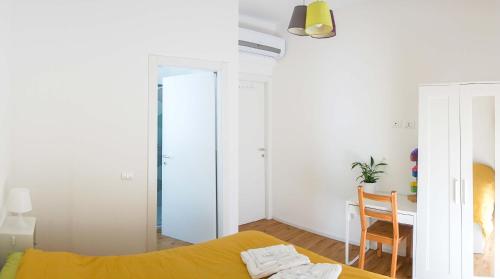 1 dormitorio con cama amarilla y escritorio en La Veranda Bed and Breakfast en Rávena