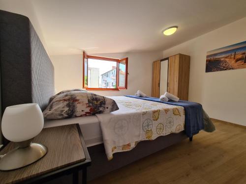 a bedroom with a bed and a table and a window at Apartments Beleca in Biograd na Moru