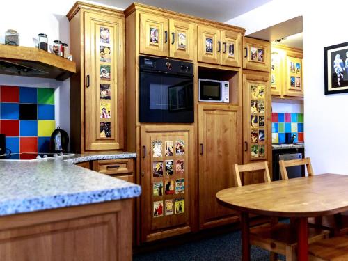 une cuisine avec des placards en bois, une table et un comptoir dans l'établissement Montmartre Apartments Monet, à Paris