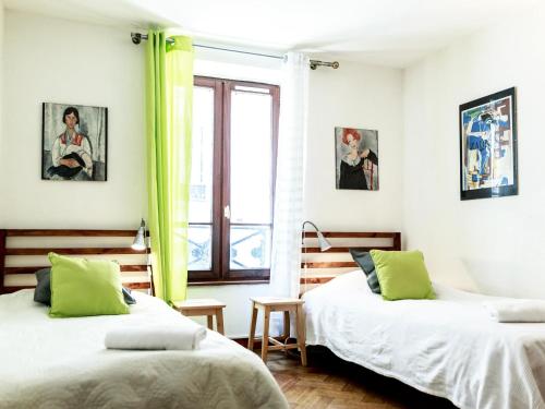une chambre avec deux lits et une fenêtre dans l'établissement Montmartre Apartments Monet, à Paris
