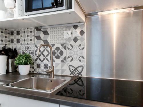 une cuisine avec un évier et un appareil en acier inoxydable dans l'établissement Montmartre Apartments Matisse, à Paris