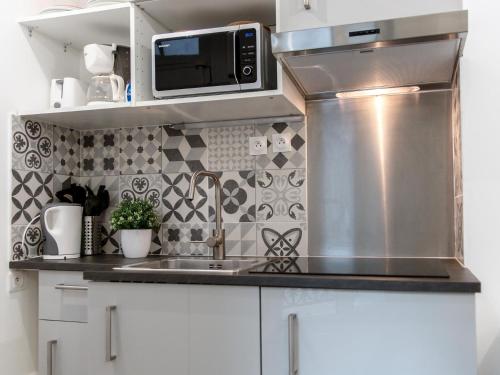 une cuisine avec un évier et un micro-ondes dans l'établissement Montmartre Apartments Matisse, à Paris