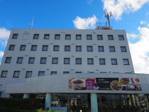 a white building with a sign in front of it at 時津ヤスダオーシャンホテル in Togitsu