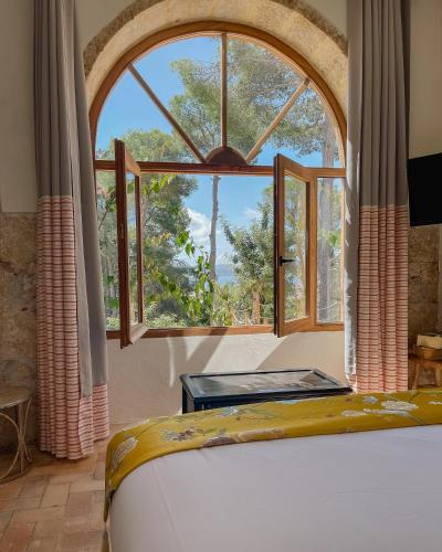a bed in a room with a large window at Villa Dora (Only adults) in Jávea