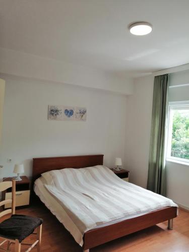 a bedroom with a large bed and a window at Apartments Branka in Ika