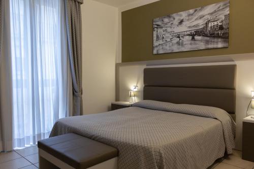 a bedroom with a bed and a large window at Hotel Cavallotti & Giotto in Montecatini Terme
