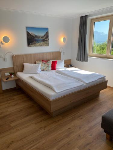 ein Schlafzimmer mit einem großen Bett mit weißer Bettwäsche und roten Kissen in der Unterkunft Dachsteinblick in Schladming
