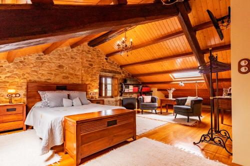 1 dormitorio con cama y pared de piedra en Casa do Mudo, en Cervo