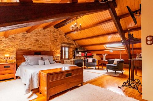 a bedroom with a bed and a stone wall at Casa do Mudo in Cervo