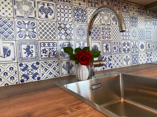 a kitchen sink with a vase with a red rose at Dachsteinblick in Schladming