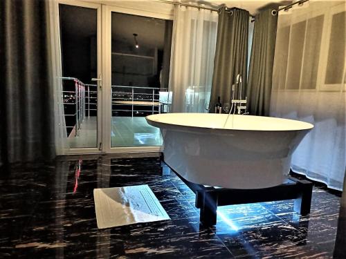 a bath tub in a room with a large window at Cazare Casa Noastra in Viforîta