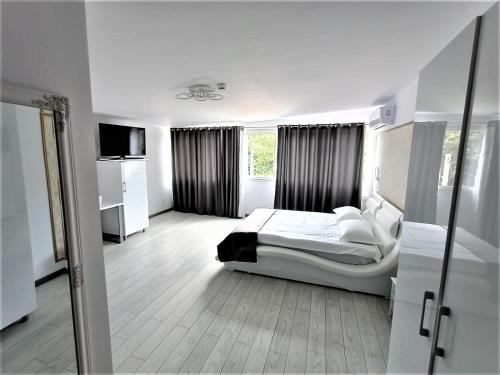 a white bedroom with a bed and a window at Cazare Casa Noastra in Viforîta