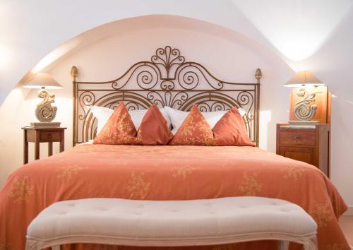 a bedroom with a large bed with an orange bedspread at Silva Apartments in Alberobello